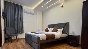 Egy modern hálószoba, amelyben található egy ágy, egy szék, egy éjjeliszemélyzet és egy mennyezeti ventilátor.