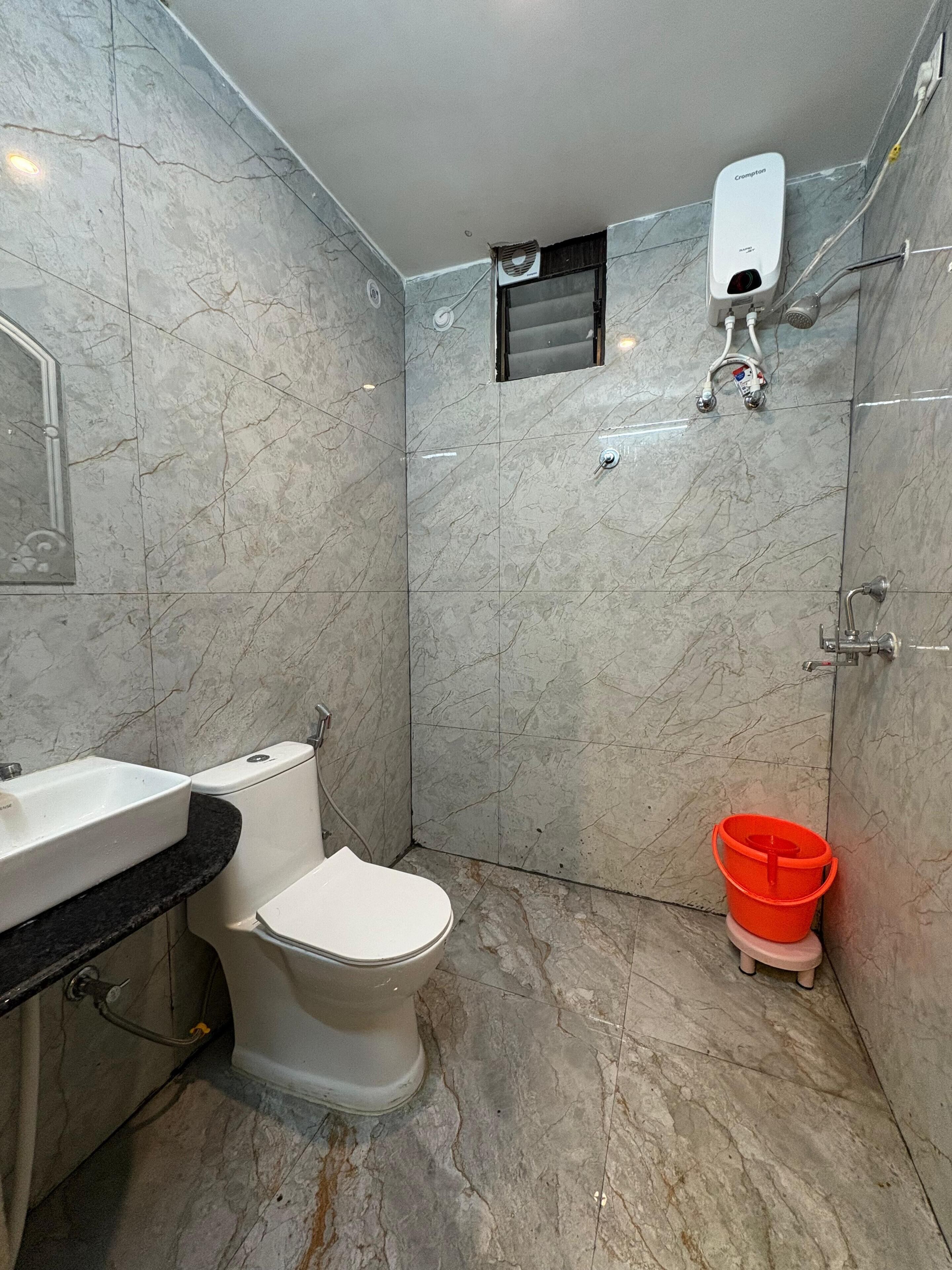 A bathroom with a toilet, sink, and shower.