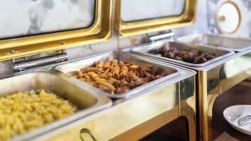 A buffet with various food options including pasta, meats, and rice.