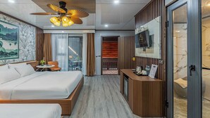 A modern hotel room with a large bed, a desk, a ceiling fan, and a TV on the wall. - Champa Phan Boutique Hotel (Vientiane)