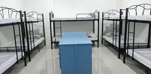 Une chambre de dortoir avec des lits superposés et une table centrale.