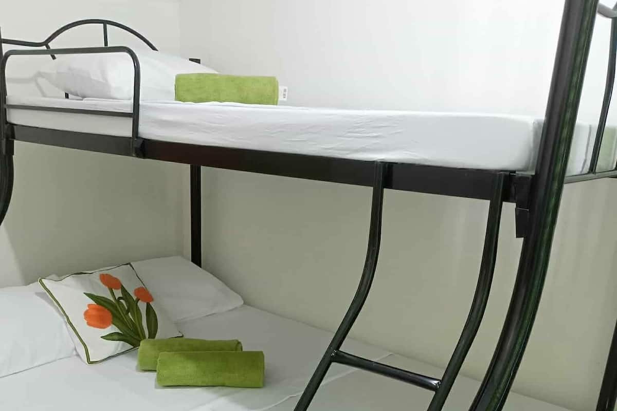 Ein Stockbett mit einer weißen Matratze und grünen Handtüchern.