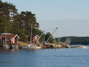 A waterfront property with a dock, a small red building, and a crane. - 4 Person Holiday Home in Tanumshede (Tanum)