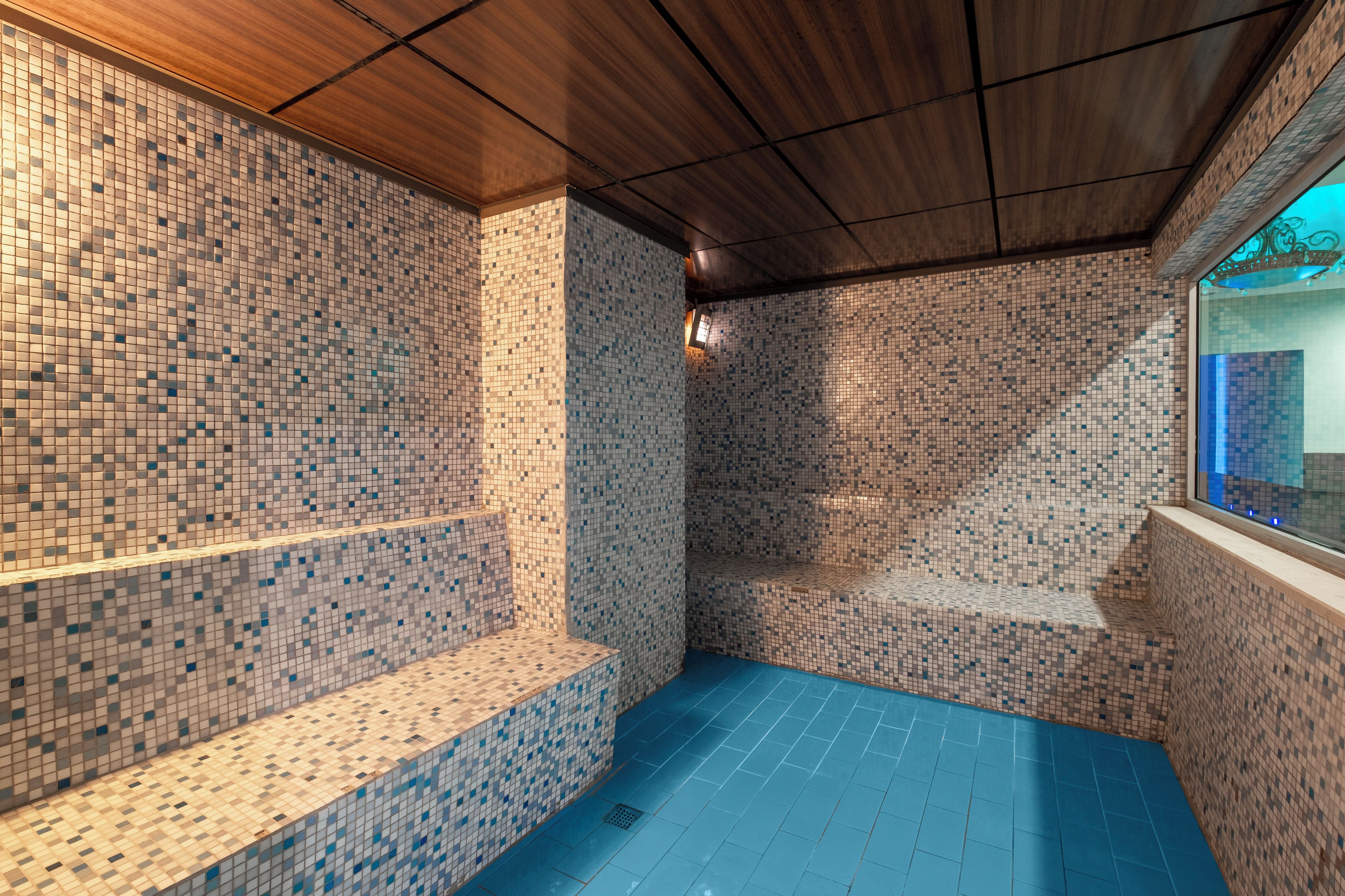 A tiled room with a bench and a window.