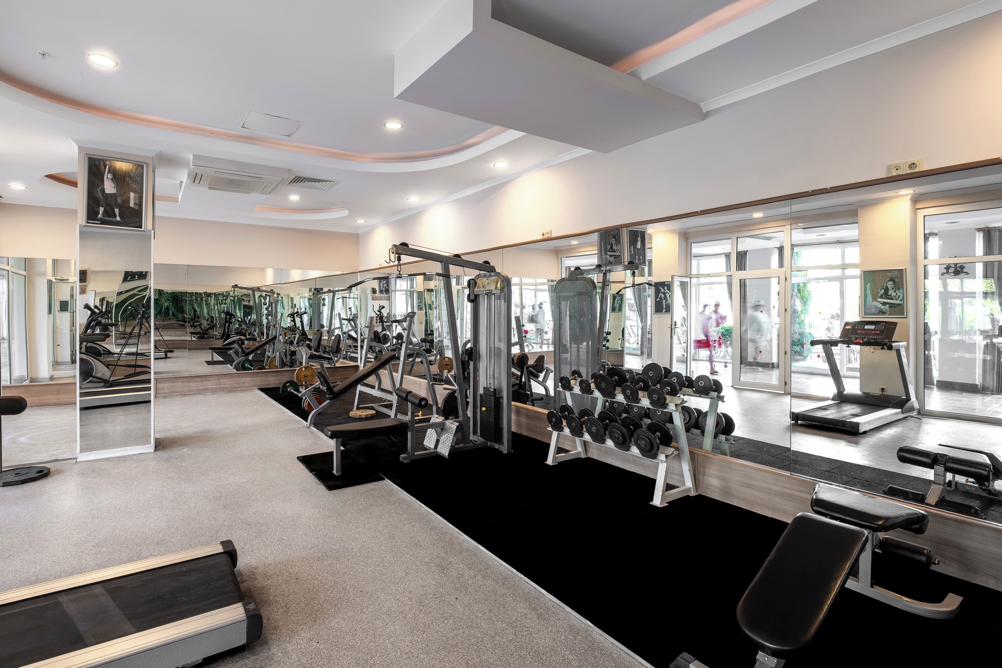 A modern gym with cardio equipment, weight machines, and free weights.