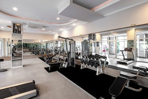 A modern gym with cardio equipment, weight machines, and free weights.