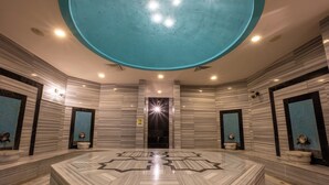 A spacious bathroom with a large central marble sink, mirrored walls, and a unique ceiling design. - Solivia Hotel (Konaklı)