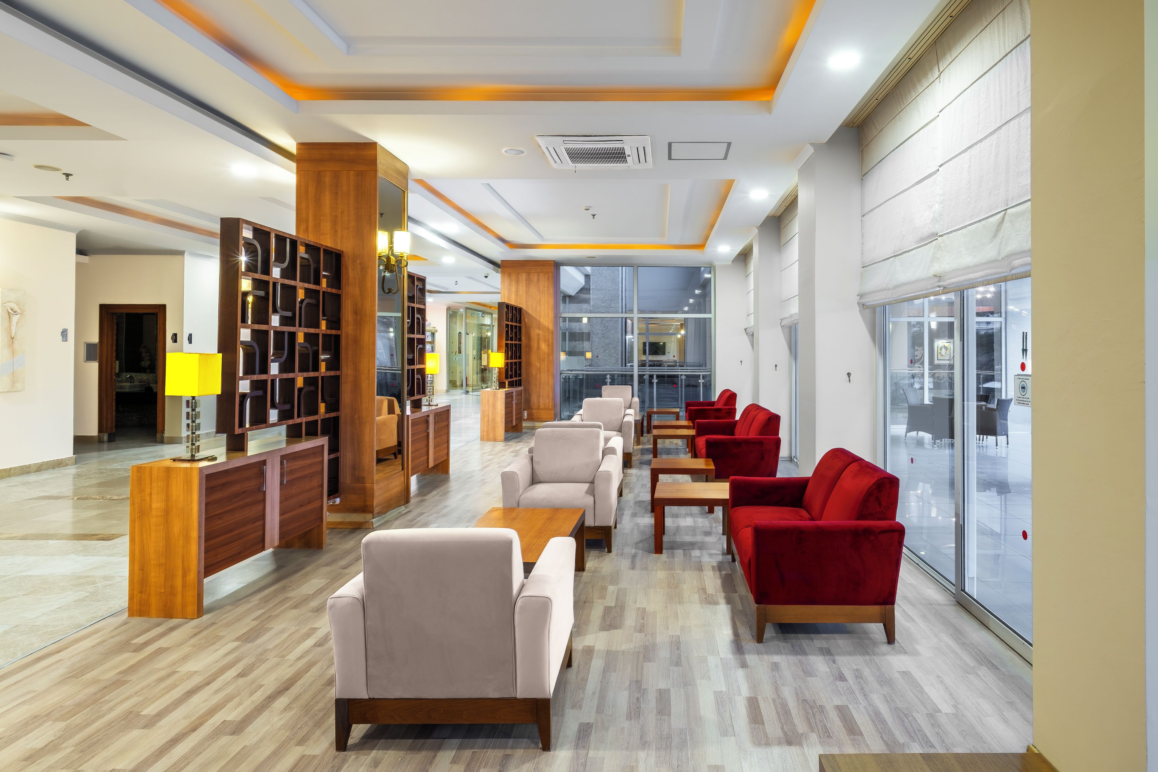 Ein modernes Interieur mit einer Rezeption, einer Sitzecke und großen Fenstern.