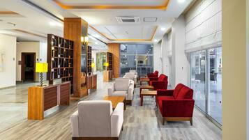 Ein modernes Interieur mit einer Rezeption, einer Sitzecke und großen Fenstern.