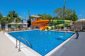A swimming pool with two water slides, lounge chairs, and umbrellas. - Solivia Hotel (Konaklı)
