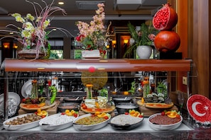 A buffet with various dishes and a potted plant.