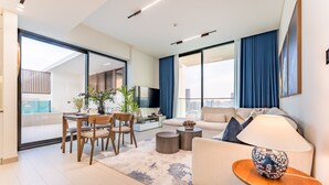 Een moderne woonkamer met een bank, salontafel en eethoek.