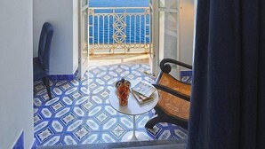 Ein Zimmer mit Meerblick, ein runder Tisch mit einem Buch und ein Stuhl.