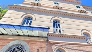 Ein mehrstöckiges Gebäude mit Bogenfenstern und Balkonen.