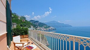 Ein Balkon mit Meerblick, einem Tisch und Stühlen sowie einem Buch.