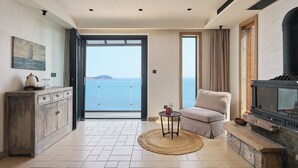 A spacious living area with a view of the sea, a fireplace, and a cozy seating area. - Nordsee Manor by Arcadia Collection (Qingdao)