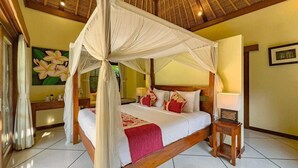A four-poster bed with a canopy, a bedside table, a nightstand, and a wall-mounted lamp. - Spacious 4BR - Villa Santai - Central Seminyak (Badung)