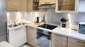 A modern kitchen with stainless steel appliances, a built-in oven, and a microwave. - Sublime luxury apartment in Charenton-le-Pont (Charenton-le-Pont)