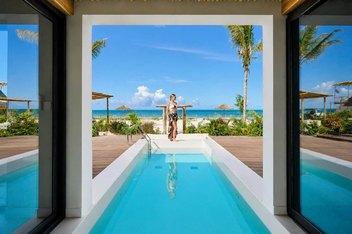 A pool area with a clear view of the beach and ocean.