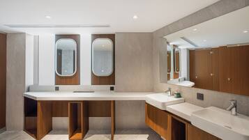 A modern bathroom with a large vanity, two mirrors, and wooden cabinetry.