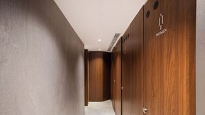 A hallway with wooden lockers and a tiled floor, leading to a door with a vent. - Oani (Taipei)