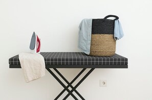 An ironing board with an iron and a cloth, a woven basket with a blue cloth, and a power outlet on a wall. - Spacious 3BR Hideway - Private Lap Pool, Peaceful, Perfect Location (Bali, Canggu, Kec. Kuta Utara, Kabupaten Badung)