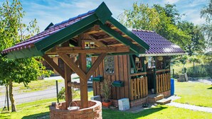 A rustic wooden structure with a sloped roof, a brick base, and a small porch area. - Die Dorfperle by Interhome (Wanna)