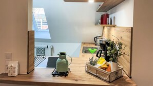 A modern kitchen with a wooden countertop, a kettle, a coffee machine, and a potted plant. - Die Dorfperle by Interhome (Wanna)