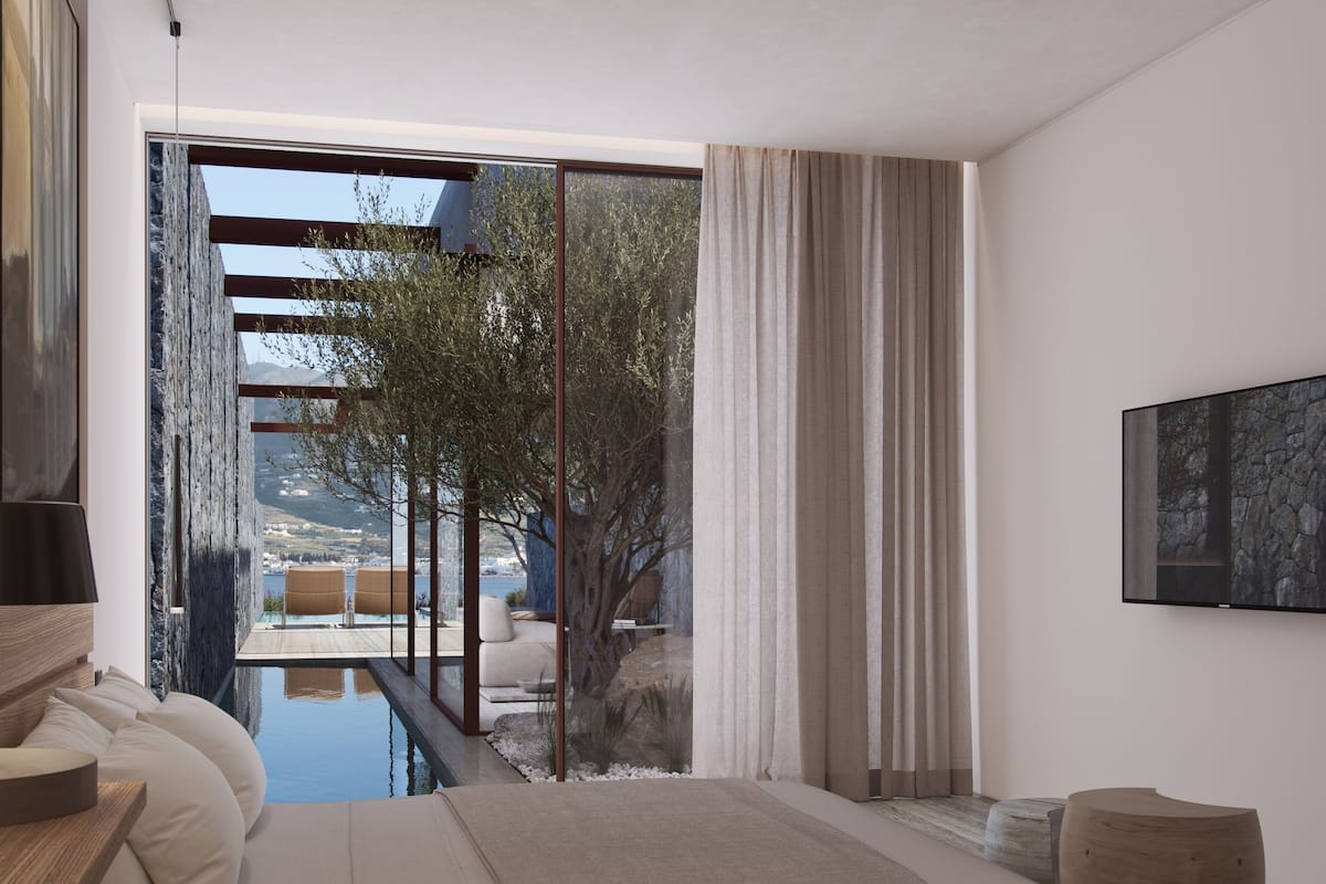 A modern bedroom with a large bed, a wooden side table, a flat-screen TV, and a view of a pool and outdoor area.