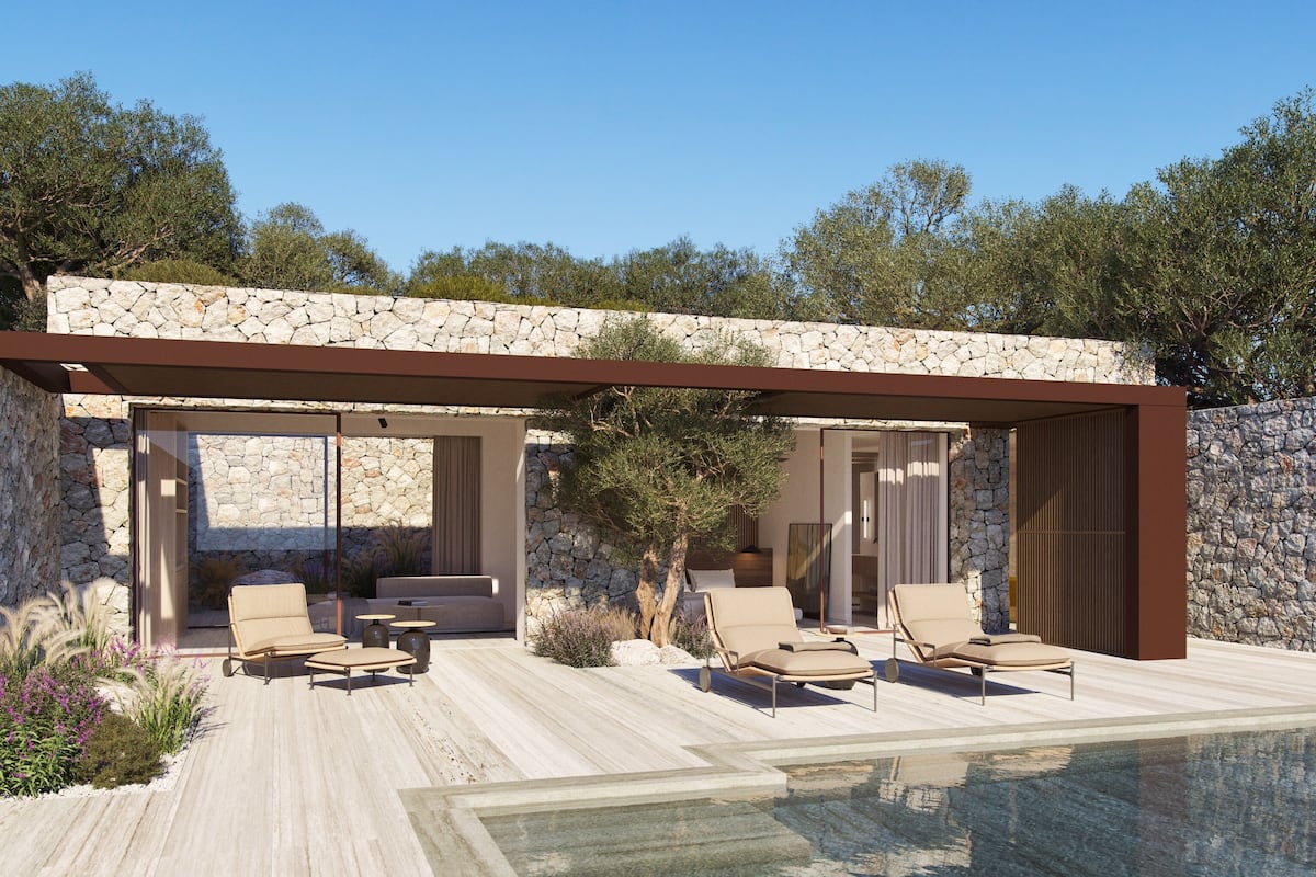 A modern outdoor pool area with lounge chairs and a stone wall backdrop.