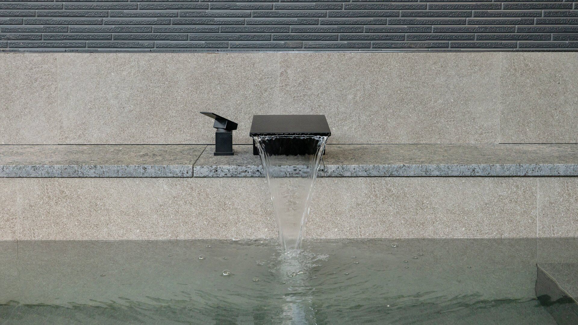 A water feature with a fountain in a courtyard.