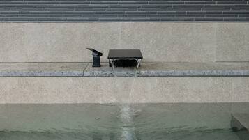 A water feature with a fountain in a courtyard.