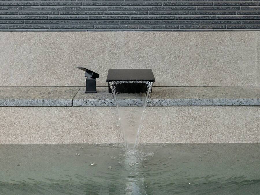 A water feature with a fountain in a courtyard.