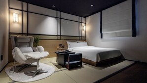 A modern bedroom with a bed, a chair, a small table, and wall-mounted lighting. - Mitasuya Ryokan Hotel by Anook Pyeongtaek Station (Pyeongtaek)