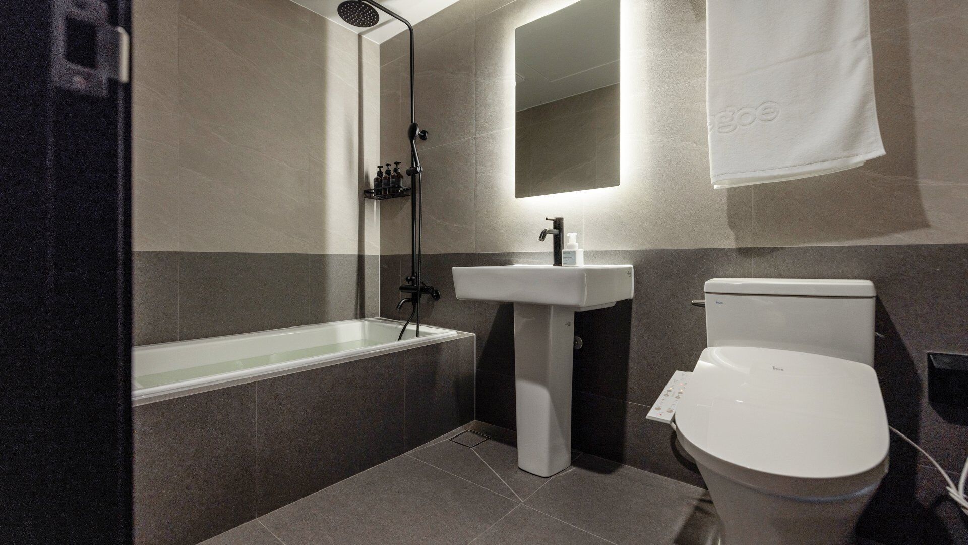 Un baño moderno con bañera, lavamanos e inodoro.