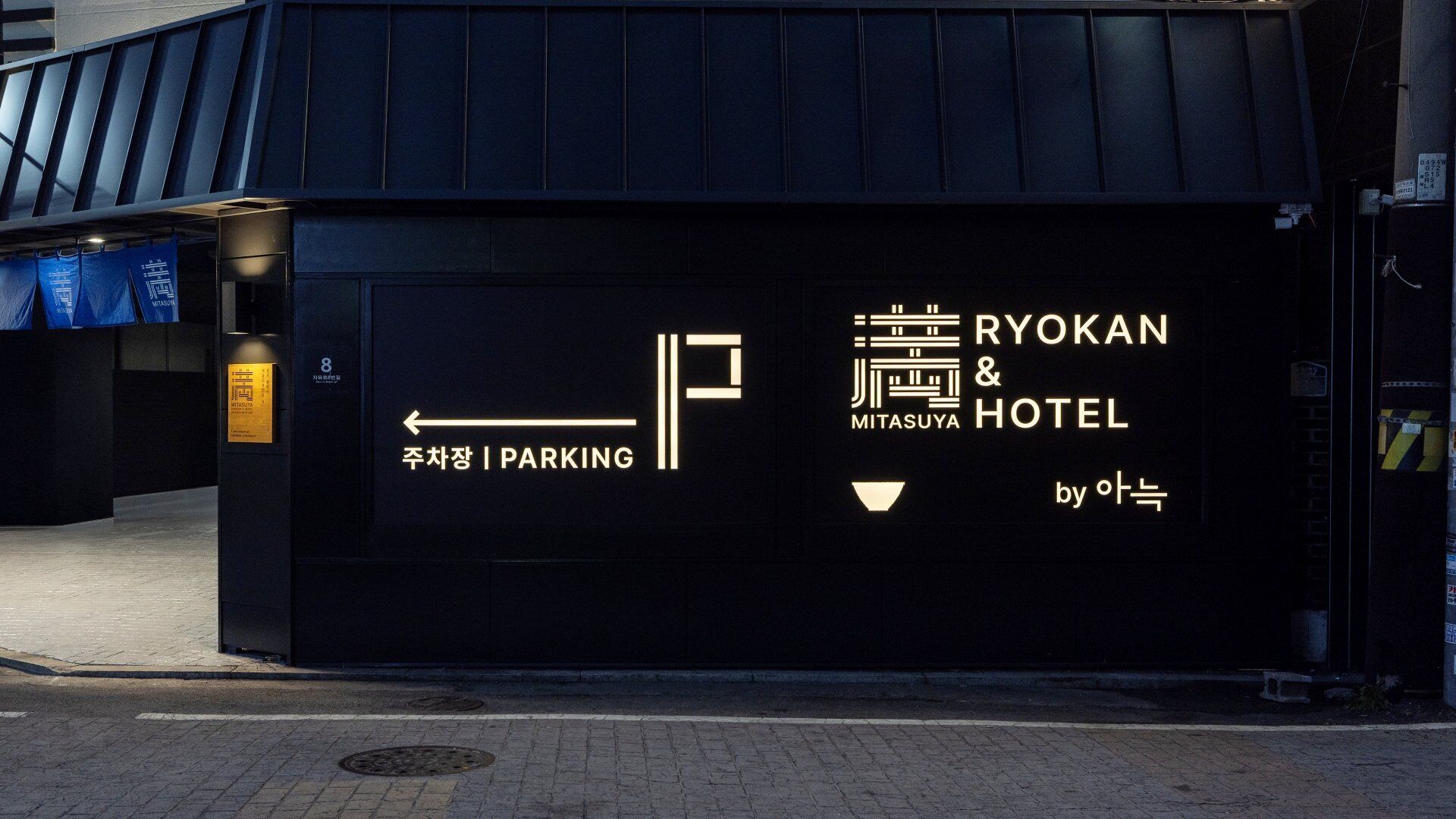 A hotel sign with directional arrows and text indicating a parking area.