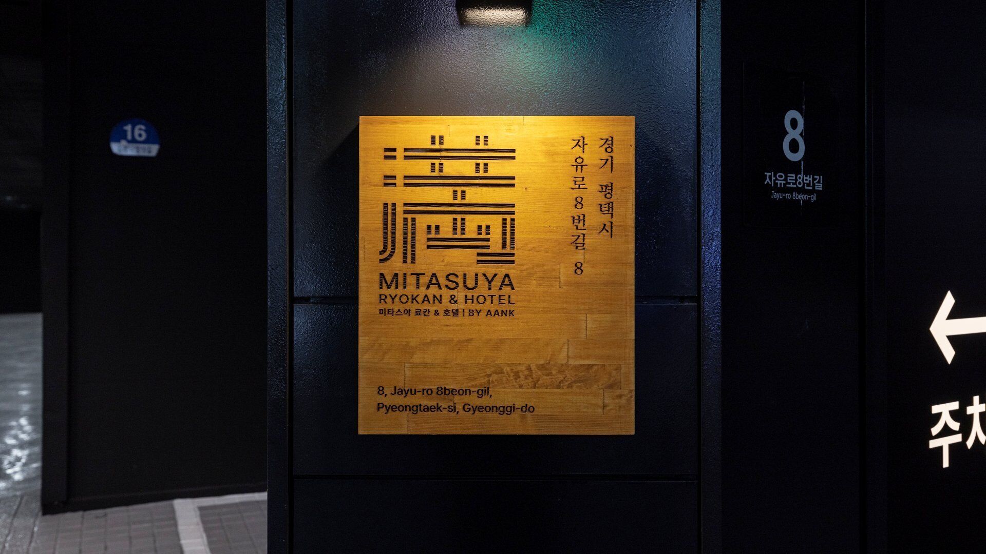 Un letrero de hotel con el nombre "MITASUYA RYOKAN & HOTEL" y su dirección.
