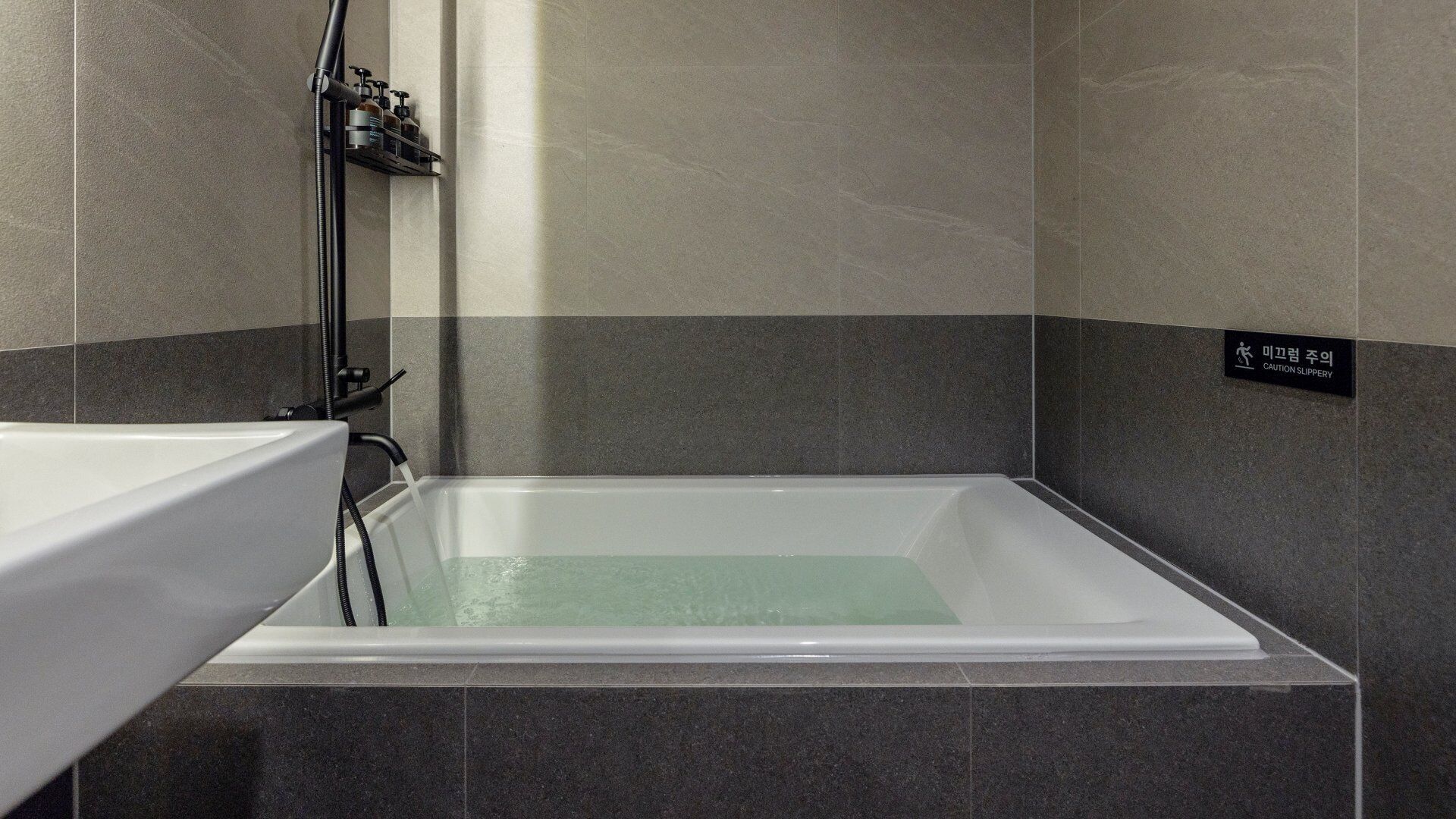 A modern bathroom with a bathtub, a shower area, and a sink.