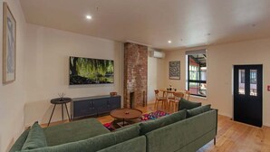 Ein modernes Wohnzimmer mit einem grünen Sofa, einem runden Couchtisch und einem Kamin.