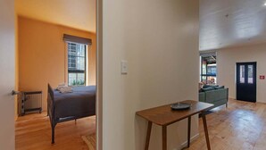 Ein Zimmer mit Bett, Tisch, Heizkörper und Blick auf einen Balkon.