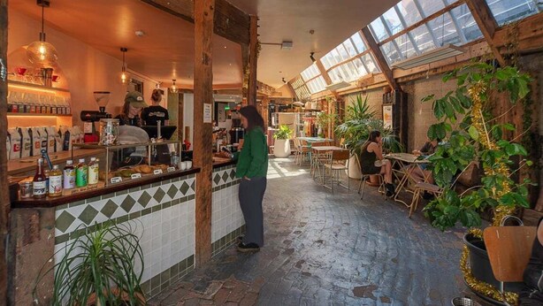Ein Café mit rustikalem Interieur, einer Bar und Sitzgelegenheiten für Gäste.