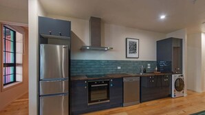 Eine moderne Küche mit Einbauofen, Geschirrspüler und Edelstahl-Kühlschrank.