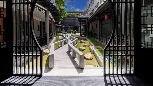 A traditional courtyard with stone lanterns, a central pathway, and a view of adjacent buildings. - ELITE James Joyce Coffetel Guangzhou  (Guangzhou)