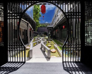 A traditional courtyard with stone lanterns, a central pathway, and a view of adjacent buildings. - ELITE James Joyce Coffetel Guangzhou  (Guangzhou)