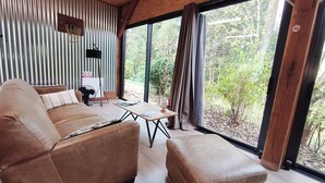 A modern living room with a sofa, ottoman, and a table. - Le lodge du bassin, Au Calme Absolu (Lindry)