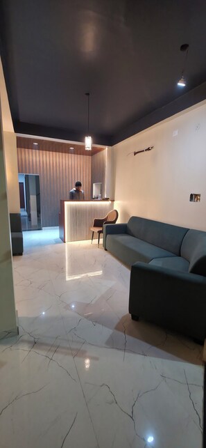 Un área de recepción moderna con un mostrador, un sofá y una silla.