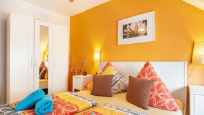 Ein Hotelzimmer mit Bett, Nachttisch, Lampe und Kleiderschrank.