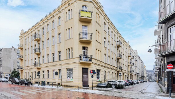 A multi-story building with a classic architectural style, featuring balconies and large windows. - Lumina bright apart near the city center (Łódź)