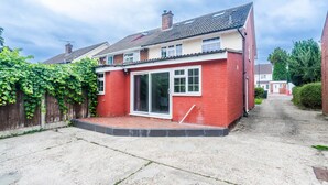 Ein rotes Backsteinhaus mit Ziegeldach, einer Haustür und einem kleinen Vorgarten.