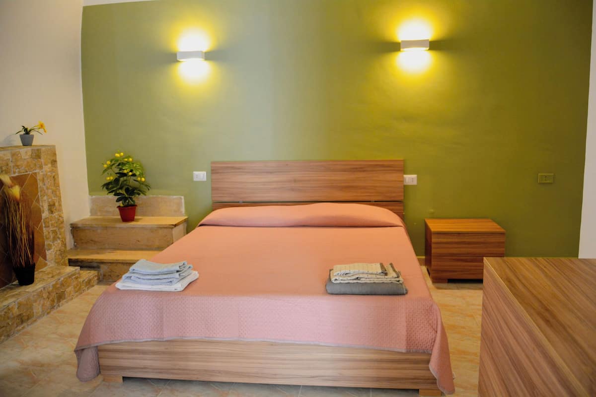A neatly arranged bedroom with a bed, bedside tables, and a nightstand.